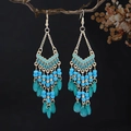 Close-up of Bohemian beaded earrings with sky blue beads and green teardrop pendants - Blue