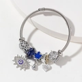 Silbernes Perlenarmband mit blauem Evil-Eye-Anhänger und Kristall auf weißem Stein - Blau