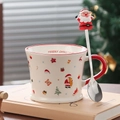 Christmas ceramic mug with Santa Claus spoon on a book against a festive background - Santa Claus (With Spoon)