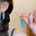 Détail de boucles d'oreilles grappe de raisin bleues en résine avec feuilles dorées - Style forme raisin vert bleu