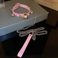 Vue macro du collier en cuir rose avec clochettes argentées et laisse en chaîne assortie - Collier avec Corde de Traction / Rose