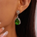 Gros plan de boucles d'oreilles émeraude verte en forme de poire et sertissage diamant - Boucles d'oreilles avec tige en argent / Vert