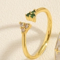 Detailed close-up of a gold adjustable ring featuring green and clear zircon stones - Triangle Green Zircon Ring