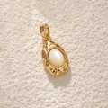 Gold plated oval pendant featuring white shell inlay on a beige textured background - A0359 Gold Irregular Oval White Shell