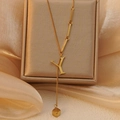 Detailopname van gouden titanium ketting met letter Y hanger op champagnekleurige zijden stof - Letter Y (WY006-Y)