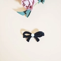 Elegant black velvet bow hair clip with a center pearl detail on a beige background - Black Flocking