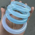 Stack of four translucent sky blue and icy white chalcedony agate bangles held in hand - 10mm Round Bangle Style / Inner Diameter 58-59mm / Sky Blue