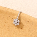 Macro shot of silver navel ring featuring a sparkling zircon flower on cork background - Dainty Flower (SE1448)