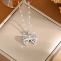 Silver bow pendant necklace with cubic zirconia micro-pave on a gold jewelry box - A0113 Silver Bowknot