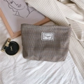 Detaillierte Makroansicht der braunen Karo-Kosmetiktasche mit Time to Party Stoffetikett - Blau & Kaffee Kariert
