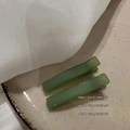 Dettaglio macro di fermagli per capelli rettangolari in resina verde avocado su piatto - Verde