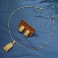 Detailed view of textured gold rectangle necklace and earrings set on blue silk - E6107-19/Gold Retro Geometric