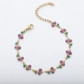 Detail of 18k gold chain bracelet with sparkling purple cherry pendant and green leaf - Gold+Purple