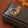Primer plano detallado del anillo de flores huecas retro con acabado plateado envejecido - Anillo Abierto De Doble Flor Plateada