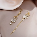 Golden peacock tassel earrings with crystals on beige silk fabric background - Gold Peacock Tassel