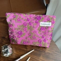 Pink vintage jacquard floral pouch with green and purple patterns on a dark wood surface - Rose Red Lychee Flower