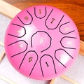 Elegant pink steel tongue drum with numbered notes on a natural wooden background - Dreamy Pink - Panda (6 Inch 11 Notes)