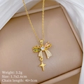 Detail of gold bow necklace with green and pink gems on a silk background - Butterfly Star Pendant (C204)