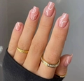 Close-up of nude pink coffin press-on nails with white wave lines on hand with rings - Nude Pink White Wavy (With Yellow Jelly Glue + File)