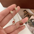 Détail de boucles d'oreilles Noël asymétriques avec Père Noël et boîte cadeau dorée - Boucles d'oreilles cadeau de Noël asymétriques
