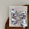 Close-up of silver leather bow hair clips with pink heart details on branded card - 1 Pair Large Bow Clips