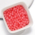 Translucent pink glass beads in a ceramic bowl for DIY jewelry making and crafts - 50Pcs/4mm / Jade-like Bead - Pink Orange