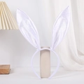 Detail of white satin bunny ears headband on a minimalist stand in a cozy setting - White Satin Bunny Ears Headband