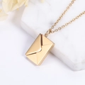 Elegant gold envelope pendant necklace for couples on a white stone and floral backdrop - Gold Love