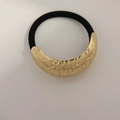 Minimalist gold alloy hair tie with a textured crescent metal accent and black elastic band - Arched Fish Scale Gold