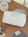 Quilted cotton makeup bag with blue floral print and bow detail on a wooden surface - Dawn White Floral - Flat Organizer