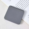 Mini foldable portable square makeup mirror in matte grey finish on book page - Silver Grey
