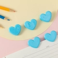 Set of five blue heart-shaped plastic paper clips on a colorful stationery background - Blue