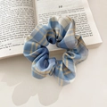 Blue and yellow plaid scrunchie with soft fabric texture on a book with soft floral shadows - 1075A Blue Yellow Plaid Scrunchie