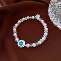 Détail d'un bracelet de perles rétro avec pendentif en pierre bleue sur satin marron - Style Pierre de Chat Bleu Lac Argenté (22#)