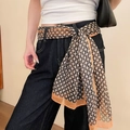 Polka dot silk scarf worn as a stylish waist belt on black denim jeans detail view - Yellow Style 40
