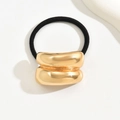 Elastico per capelli nero con ornamento geometrico in metallo dorato su sfondo neutro - Oro