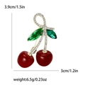 Sparkling cherry brooch with red crystals, golden stem, and green leaves with dimensions - Red