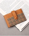 Detail view of caramel leather and houndstooth card holder on an open book - Brown