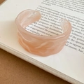 Macro detail of irregular wavy pale pink resin open bangle on vintage book pages - Wrinkle Wave Design / Pale Pink Marble