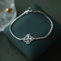 Detail of silver clover charm bracelet with white zircons on a dark green jewelry box - 81# Bracelet - Silver - Flower (real Gold Plated)