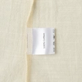 Detailed close-up of 100% cotton fabric texture and care label on a sleeveless dress - S / Apricot