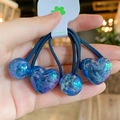 Dettaglio di elastici per capelli blu in resina con cuori glitterati e etichetta fatta a mano - Blu scuro