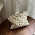Primer plano de neceser acolchado con estampado de corazones sobre mesa de madera - Pequeño Corazón Negro