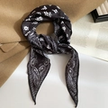Dettaglio di un foulard in seta con motivo Paisley bianco e nero su un cappotto elegante - Collana a Sciarpa / Nero Paisley