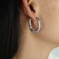 Polished silver U-shaped oval hoop earrings in stainless steel on female model - EH41 Oval / Silver