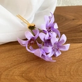 Dettaglio ravvicinato di una forcina con fiori in tessuto viola e forchetta in metallo dorato - Bacchetta d'oro (Fiore viola) / Viola