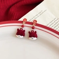 Close-up of red flocked calf earrings with golden Fu character studs on ceramic plate - 925 Silver Needle / Red Flocked Pony Style (HE29854)