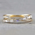Macro shot of a gold crossover ring featuring round and rectangular micro-pave crystals - US 5 / Gold