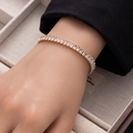 Close-up of a gold tennis bracelet with baguette-cut clear zircon stones on a wrist - Gold Medium Rectangle