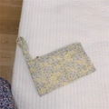 Macro detail of floral fabric mini pouch showing lavender and yellow patterns with zipper - Yellow and Purple Floral